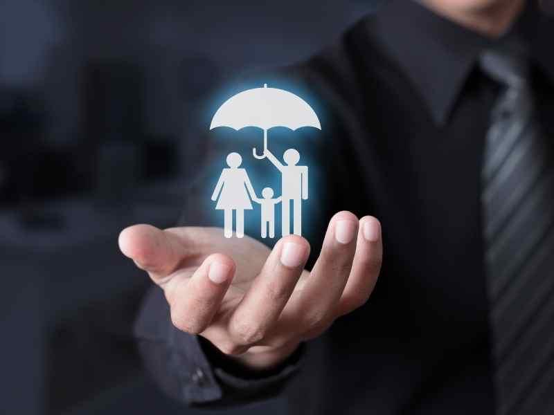 Mano de empresario sosteniendo un ícono de familia bajo un paraguas, ilustrando cómo las empresas familiares proyectan seguridad, cuidado y confianza social.